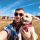 Man in Hawaiian shirt and sunglasses with a dog 