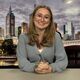 Student Georgia Cook sitting in front of a presenting screen with a city scape