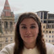 Student smiling with skyline behind 