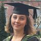 Student Tabitha Wilson in a graduation cap and gown, holding flowers