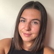 A selfie of Becca Brown against a white wall.