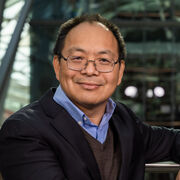 Professor Meihong Wang smiles as he stands in the Engineering Heartspace