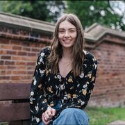 Caroline Lilley in the law school garden with boundary wall behind her