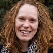 Leigh Brown wearing a leopard print scarf, looking happy