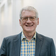 Richard Bruce wearing a checked shirt and a jacket.