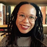Professor Akwugo Emejulu in front of a bookshelf