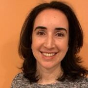 Laura M Maratou-Kolias in front of an orange wall