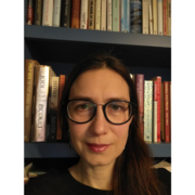 Anna Zueva in front of a bookshelf.