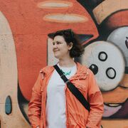 Image of Dr Ellie Harrison stood in front of a graffitied wall