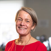 Portrait of a person smiling, with short straight blonde hair