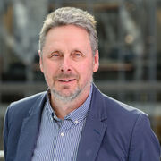 Portrait of academic with blue striped shirt and blue jacket