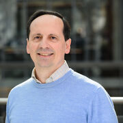 Portrait of academic with blue jumper, smiling