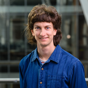 Male with brown hair in denim blue shirt