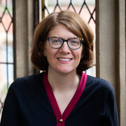 Portrait of a person with short straight brown hair wearing glasses
