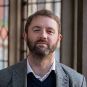 Portrait of a person with a beard smiling