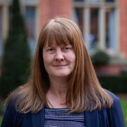 Portrait of a person smiling, with long straight auburn hair