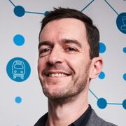 An image of Robert Langley in a suit stood in front of a graphical background.