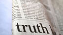 A newspaper zoomed in with the word 'truth' in large letters