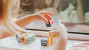 Girl playing with small wooden letter blocks on a wood surface.