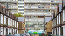 a block of flats overlooks a street with parked cars