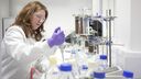 A woman in a lab coat conducts an experiment