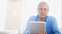 Senior man using digital tablet at home