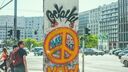 Piece of the Berlin Wall with an orange peace sign spray painted on it