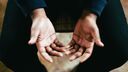 A person's hands on their lap with palms pointing upwards