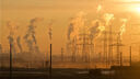 Electricity pylons and chimneys with plumes of smoke
