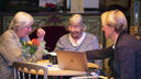 Younger male showing music technology equipment to elderly lady 