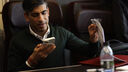 Rishi Sunak looking at a phone, whilst on a train 