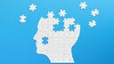 Brain shaped white jigsaw puzzle on blue background. Mental health and problems with memory.