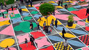 A brightly patterned children's play area painted on tarmac