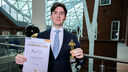 Man standing with certificate and trophy 