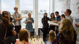 Staff member talking to students at exhibition