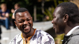 A student outside the students union smiling 