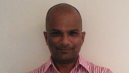 Headshot of professor bhavani shankar stood with arms folded against a cream background