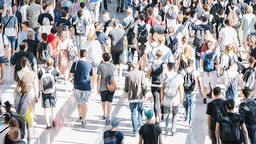 A large group of people in public. It's sunny - they're dressed for summer.