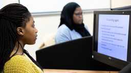 Two students revising on the computer in the library. 