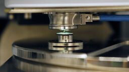 An image of a green light shining on the probe of the atomic force microscope