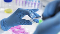 A scientist pipetting a sample into a vial.