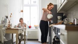Carer makes cup of tea in kitchen
