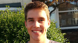 Daniel standing in front of a house, in the sun