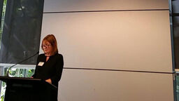 A presenter giving a speech at a stand