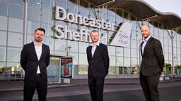 Three representatives from the University of Sheffield, DSA and Peel L&P stood in front of DSA's terminal building