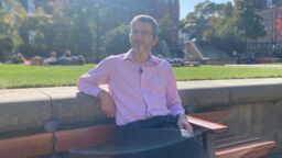 Man outside sat on bench