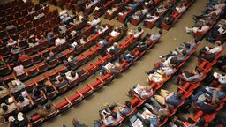 A large number of people seared in a large auditorium.