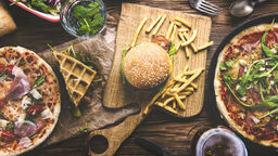 pizza, burger and chips displayed on a table