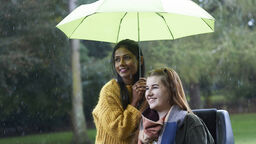 An image of a wheelchair user with a companion outside together.