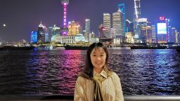 Education graduate with harbour and skyscrapers in background